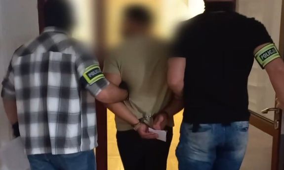 dwóch policjantów nieumundurowanych prowadzi zatrzymanego