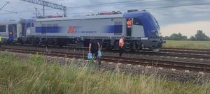 policjanci niosą wodę dla pasażerów pociągu