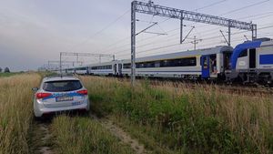 policjanci niosą wodę dla pasażerów pociągu