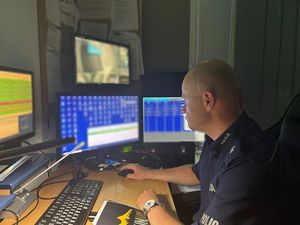 na zdjęciu umundurowany policjant siedzący za biurkiem