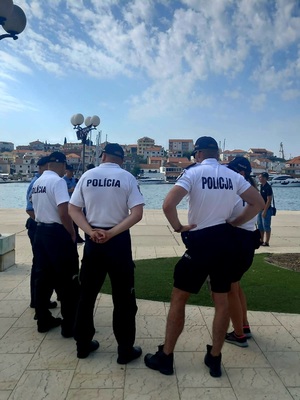 Umundurowani policjanci w tle w tle woda i budynki