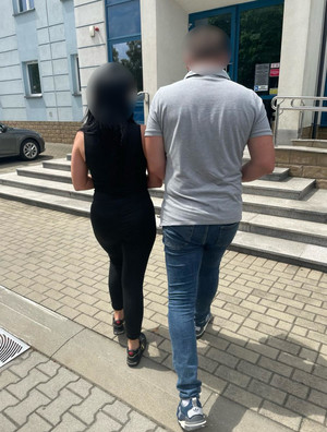 zatrzymana kobieta prowadzona przez nieumundurowanego policjanta