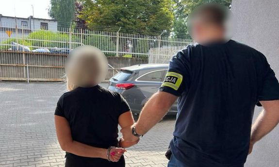 zatrzymana kobieta prowadzona przez nieumundurowanego policjanta