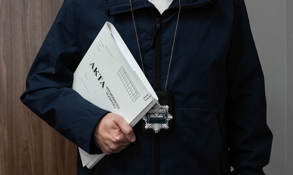 osoba z katami sprawy trzymanymi w ręce