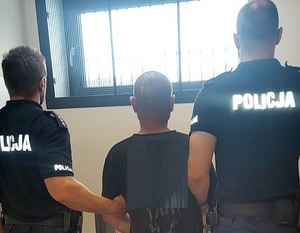 dwaj funkcjonariusze z zatrzymanym