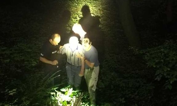 policjant z mężczyzną podtrzymują za ramiona odnalezionego seniora