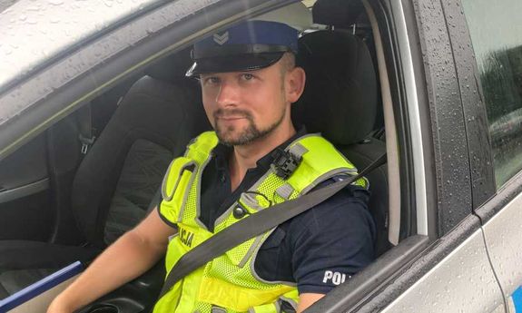 policjant siedzi za kierownicą w radiowozie