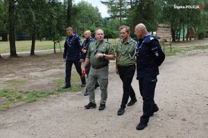 komendanci policji rozmawiają z opiekunami obozu harcerskiego