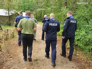 widok na plecy komendantów i opiekunów obozu harcerskiego