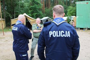 komendanci policji rozmawiają z opiekunami obozu harcerskiego
