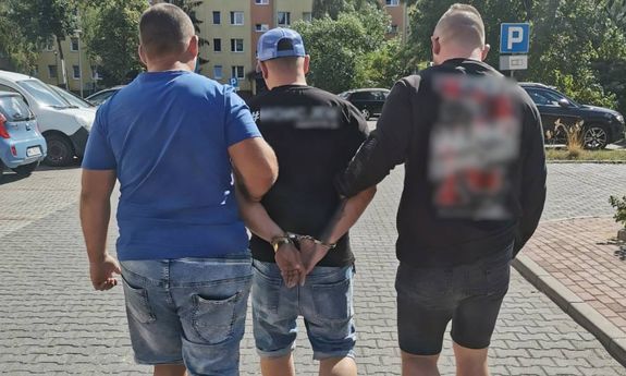 policjanci idą z zatrzymanym