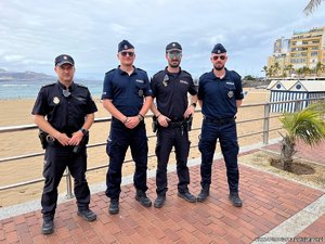 policjanci pozują do zdjęcia na tle plaży