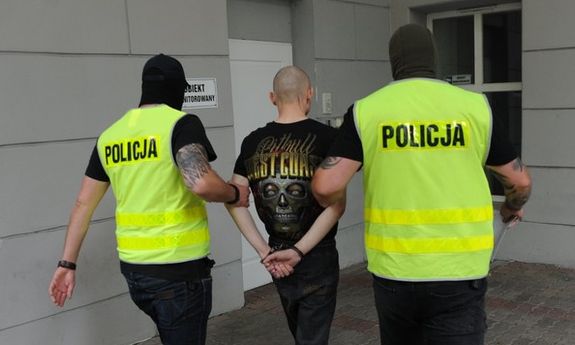 policjanci prowadzą zatrzymanego mężczyznę
