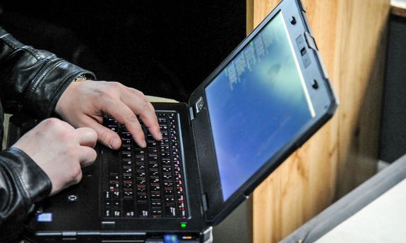 ręce mężczyzny piszą coś na laptopie