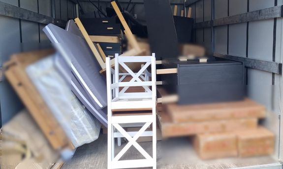 w garażu metalowym leżą kartony z meblami