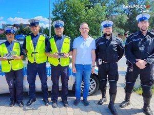 wspólne zdjęcie  policjantów i mężczyzny w białej koszulce