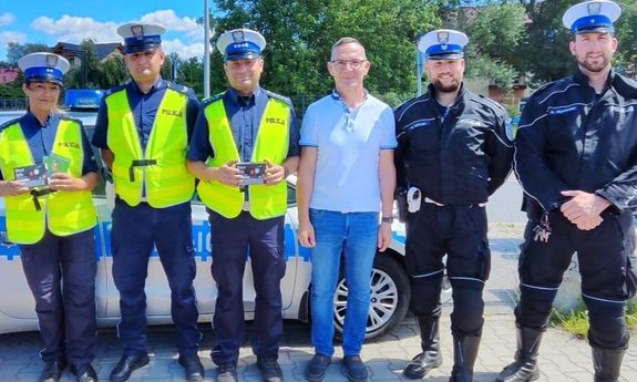wspólne zdjęcie  policjantów i mężczyzny w białej koszulce