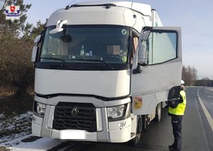 policjant w mundurze kontrolujący samochód ciężarowy