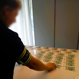 policjant rozkłada pieniądze na stole