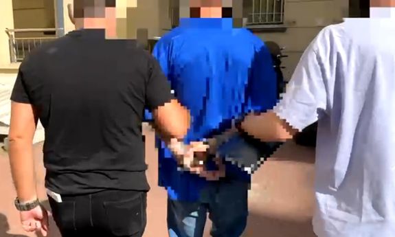 policjanci prowadzą zatrzymanego