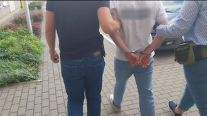 Policjant prowadzi zatrzymanego
