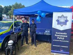 Para policjantów pozuje do zdjęcia przy stoisku profilaktycznym.