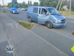 bus stojący na ulicy, za nim radiowozóz policyjny