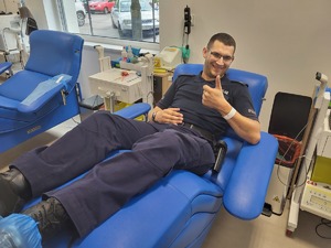 na zdjęciu umundurowany policjant w trakcie oddawania krwi