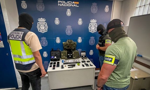 policjanci z różnych krajów stoją nad poukładanymi rzeczami