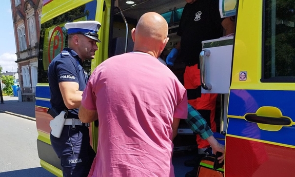 Funkcjonariusze policji pomagający osobie, która zasłabła