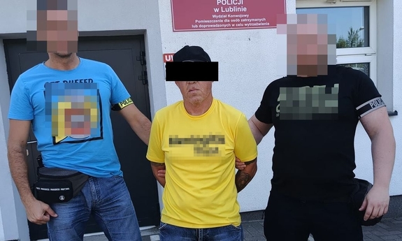 dwaj nieumundurowani funkcjonariusze z zatrzymanym w kajdankach