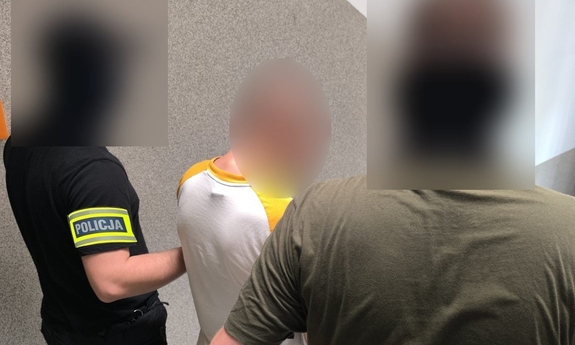 na zdjęciu dwóch policjantów prowadzi zatrzymanego mężczyznę