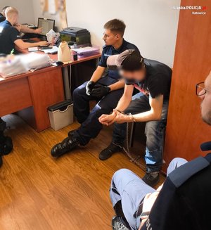 zatrzymany siedzi na krześle w budynku policji