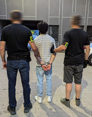 policjanci stoją z zatrzymanym