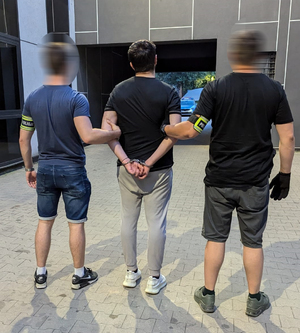 policjanci stoją z zatrzymanym