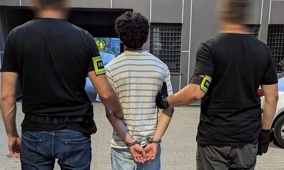 policjanci stoją z zatrzymanym