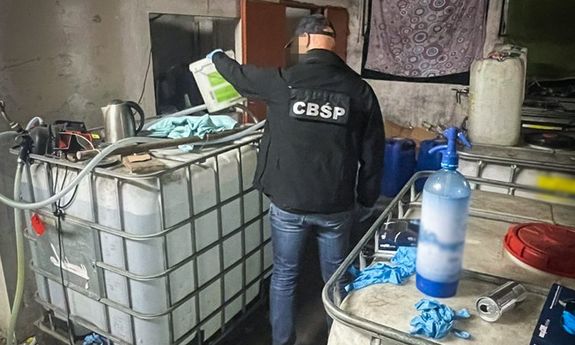 policjant cbśp stoi na środku pomieszczenia, a obok niego stoją duże butle