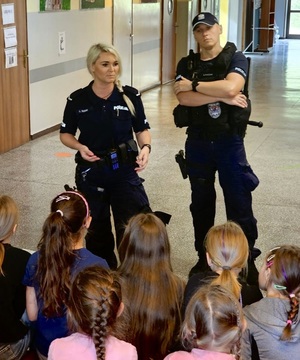 Para policjantów z grupą dzieci podczas prelekcji.