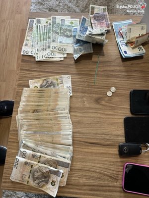 na stole leżą zabezpieczone pieniądze, telefony komórkowe i kluczyki do samochodu