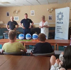Policjant i strażak podczas prelekcji z grupą dzieci.