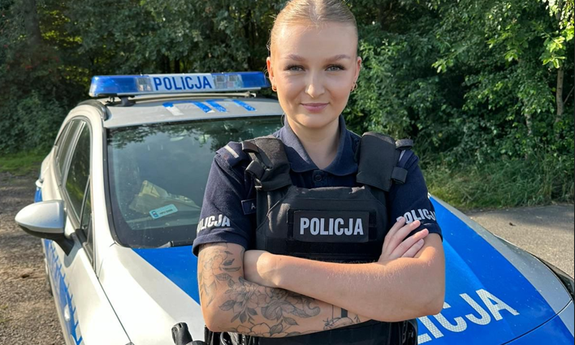 umundurowana policjantka stoi przy radiowozie