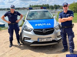 sierż. szt. Arkadiusz Cekała i post. Wojciech Szeląg stoją przy radiowozie policyjnym