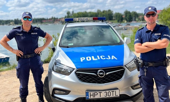 sierż. szt. Arkadiusz Cekała i post. Wojciech Szeląg stoją przy radiowozie policyjnym