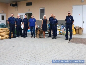 policjanci pozują do zdjęcia z kobietą i psem