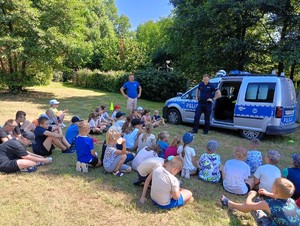 Policjant z grupą dzieci podczas prelekcji.