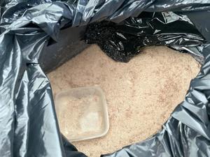 zabezpieczone narkotyki w sypkiej postaci w czarnym woreczku