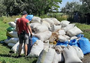 Policjant obok worków z zabezpieczoną kontrabandą