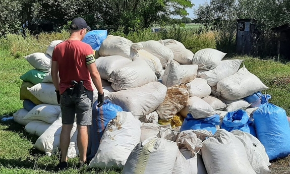 na zdjęciu policjant obok worków z zabezpieczoną kontrabandą