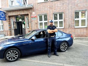 policjant stoi przy radiowozie