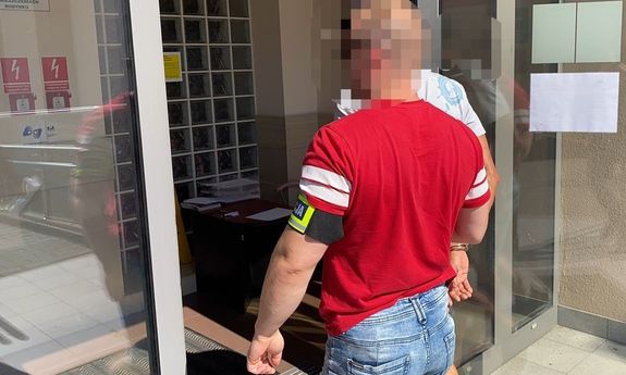 policjant idzie z zatrzymanym